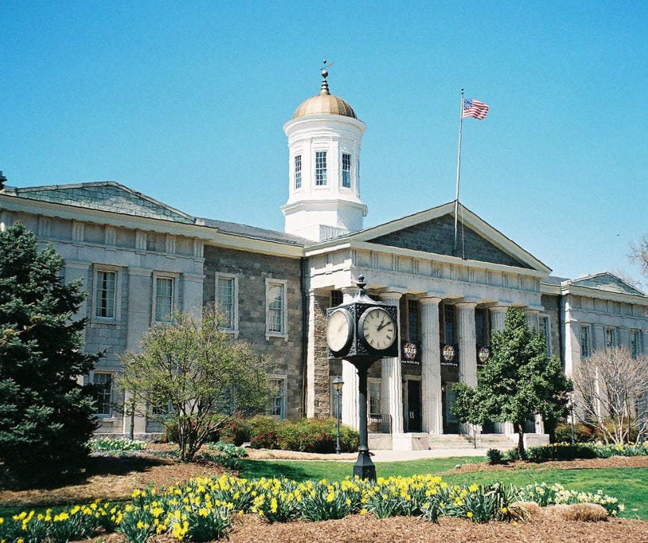 Calvert County Courthouse building with American flag, clock monument, and landscaped garden in Maryland
