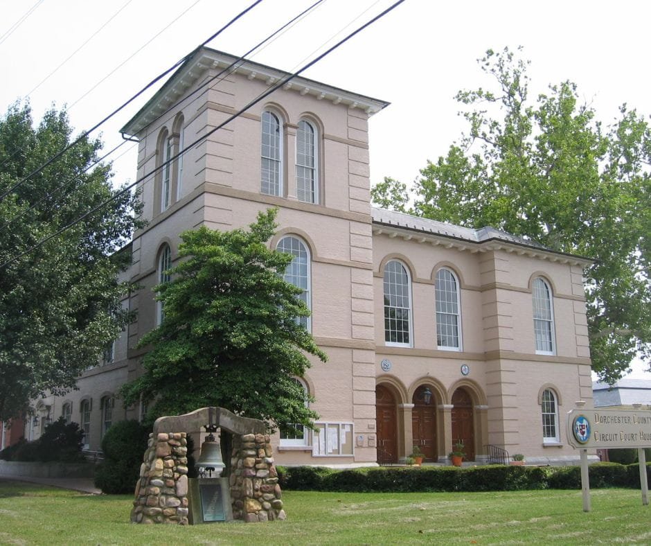 A historic downtown street at dusk with glowing shop windows and a theater marquee.
