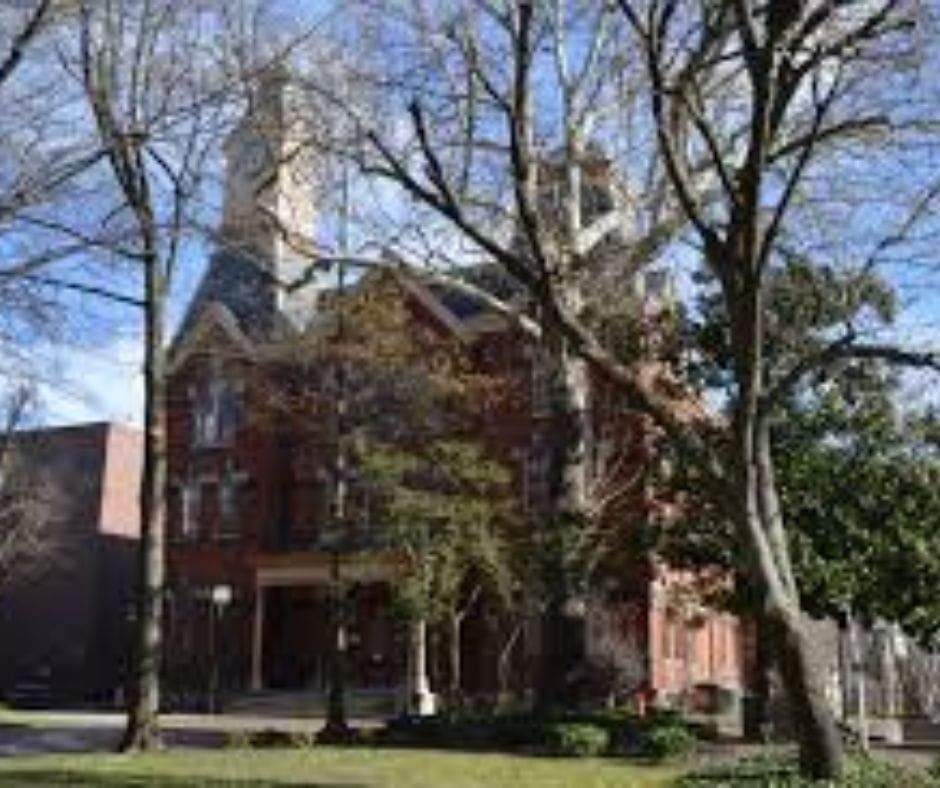 Caroline County Courthouse with red brick, white pillars, and a clock tower.